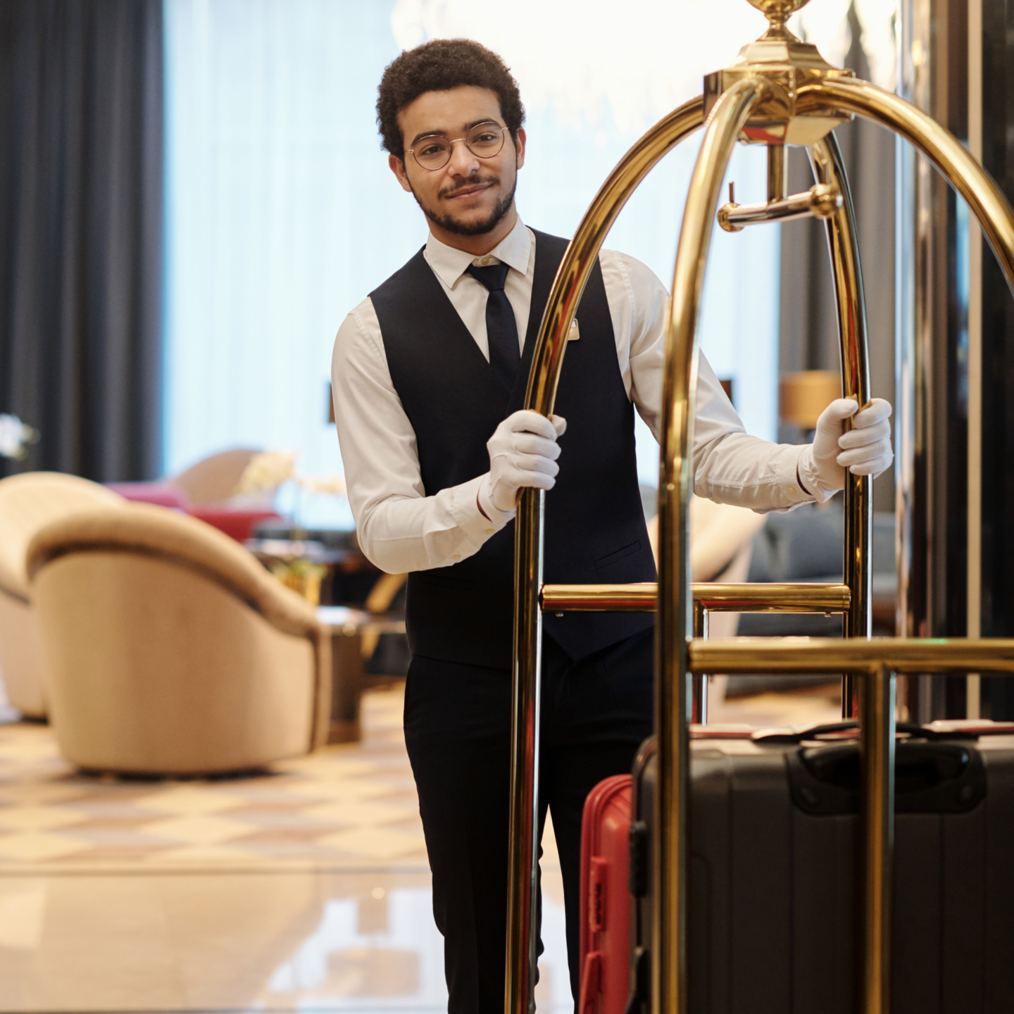 bellboy carrying luggage for hotel guests